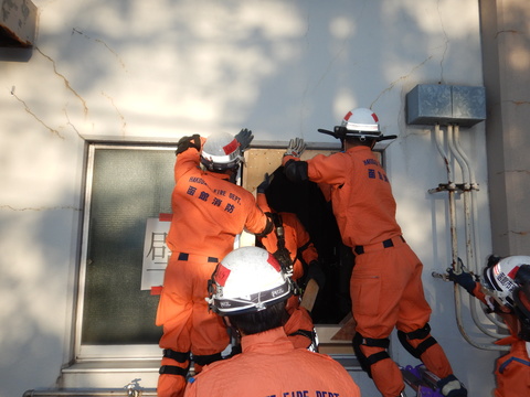 倒壊した建物の窓を補強している写真