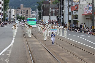 港まつりで演奏しながらパレードしている写真