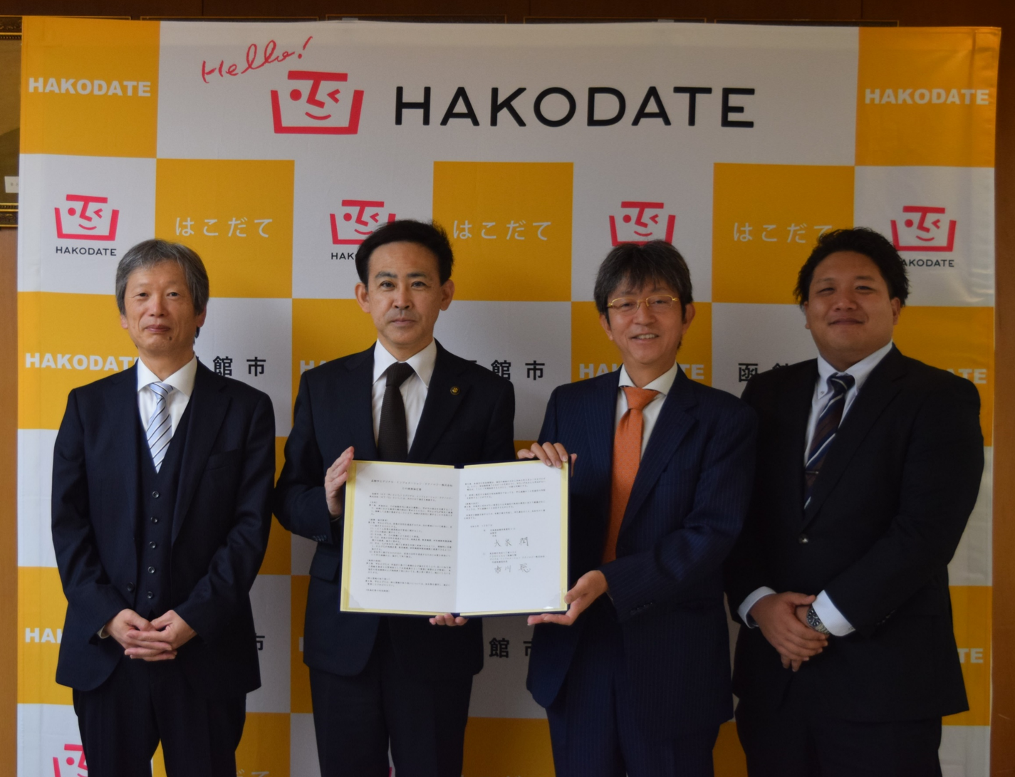 締結式のようす。左から，成田執行役員，大泉市長，市川代表取締役社長，庄司様