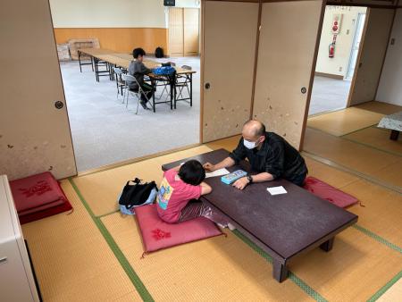本通町会館で指導員が児童に学習支援をしているようす